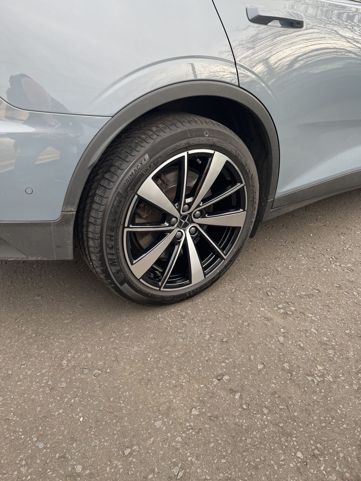 A diamond-cut black and silver alloy on a grey car